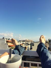 Low section of man having food against sky in city