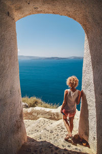 Woman standing on a covered footpath by the sea