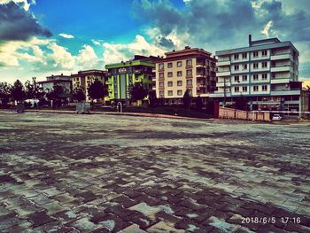 Street by buildings against sky