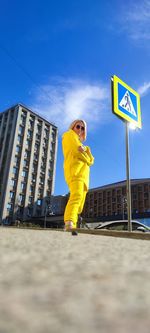Low angle view of man standing against yellow sky