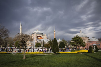 Group of people in front of buildings against sky