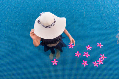 High angle view of woman holding flowers in swimming pool