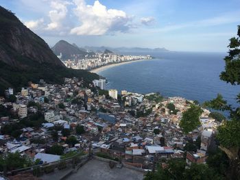 High angle view of city by sea against sky