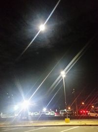 Illuminated street light against sky at night