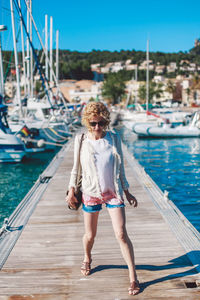 Full length of young woman standing on pier