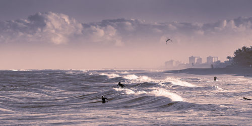 People on sea shore against sky