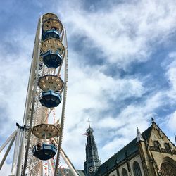 Low angle view of ferris wheel against cloudy sky