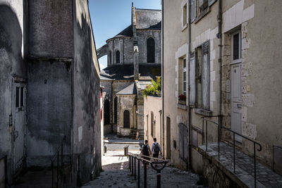 People on alley amidst buildings in city