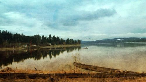 Scenic view of lake against cloudy sky