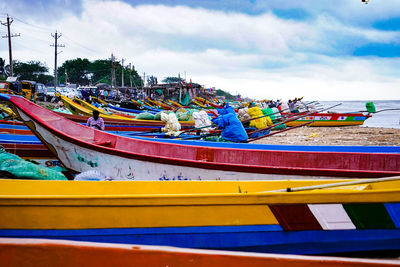 Multi colored boats moored at harbor against sky