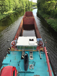 Boats sailing on river by trees