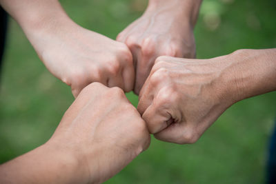 Cropped image of friends clinching fist