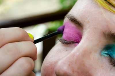 Close-up of woman applying eyeshadow