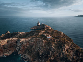 Rock formations by sea against sky