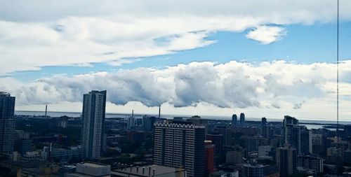 View of cityscape against cloudy sky