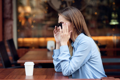 Midsection of woman with coffee cup in restaurant