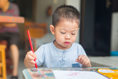 Boy drawing on table at home