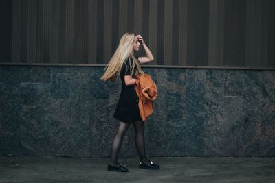 Young woman standing on wall