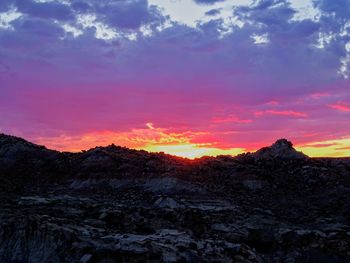 Scenic view of silhouette mountains against sky at sunset