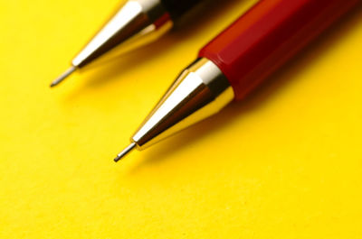 Close-up of mechanical pencils against yellow background