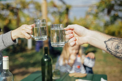 Midsection of man holding wine glass