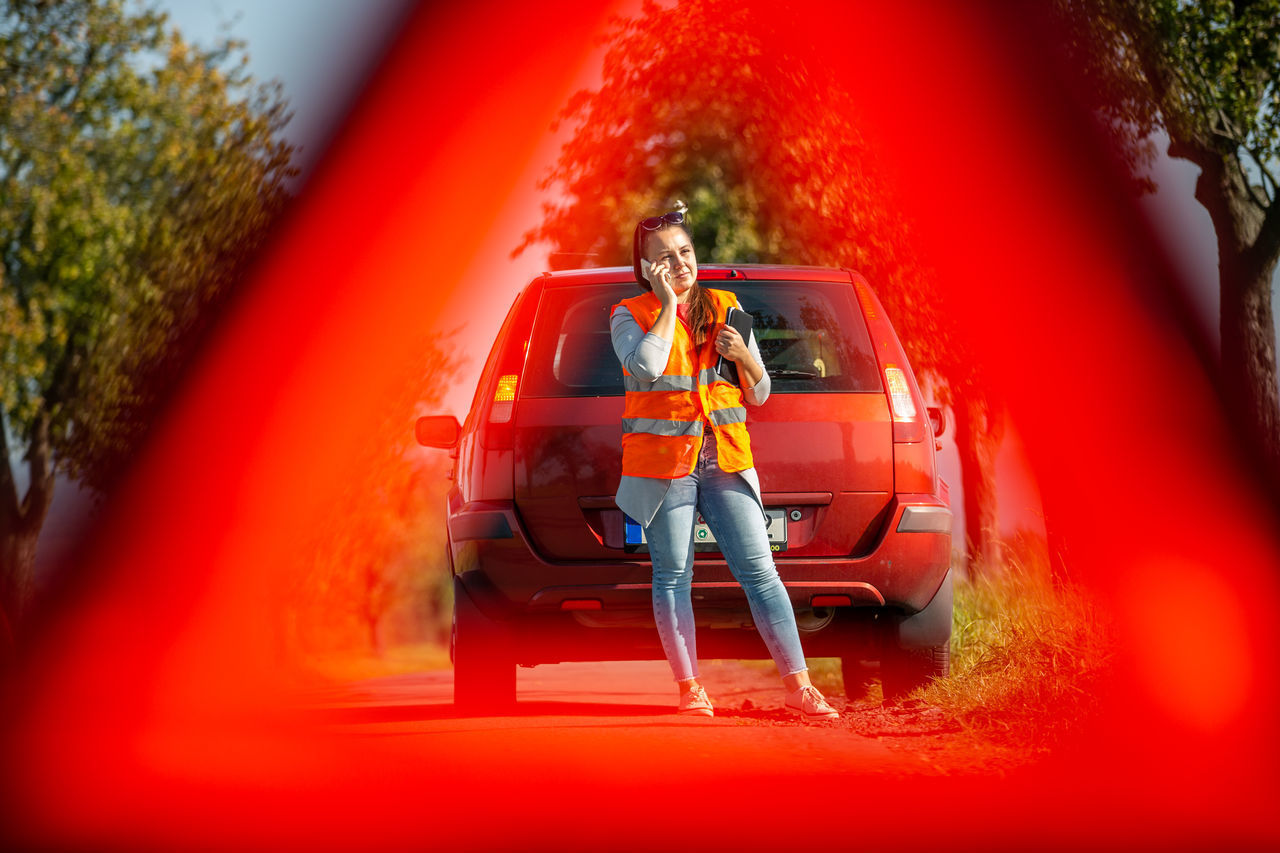 WOMAN SITTING ON RED CAR