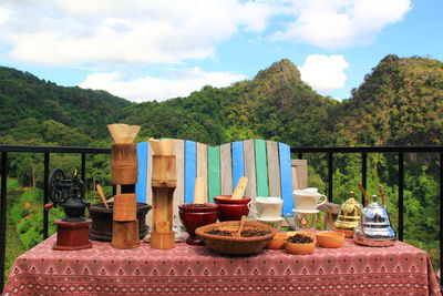 Lounge chairs and table against trees on landscape