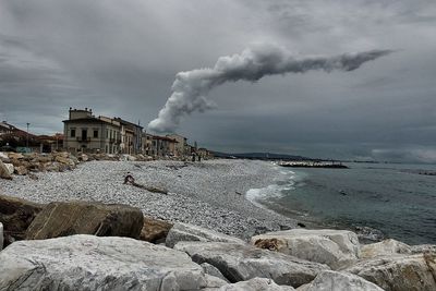 Smoke emitting from sea against sky