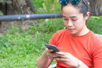 Low angle view of boy using mobile phone outdoors