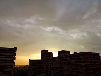 Low angle view of buildings against sky at sunset