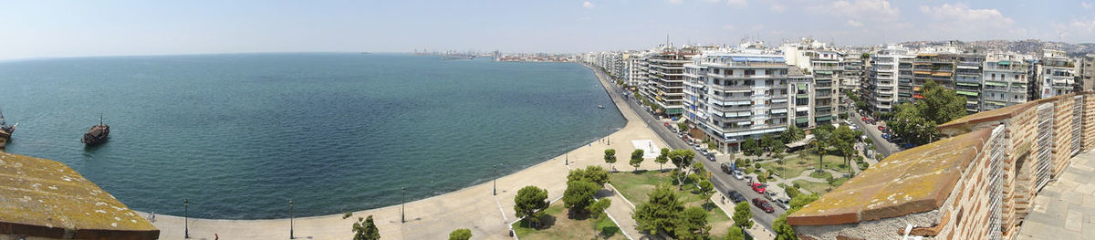 Panoramic view of buildings and sea against sky