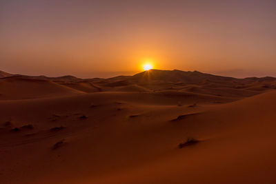 Scenic view of desert against sky during sunset