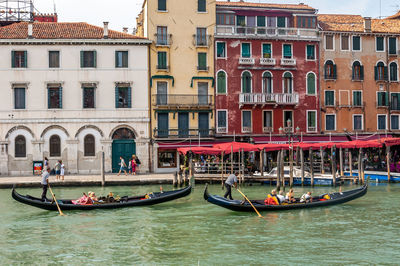 Boats in canal against buildings in city