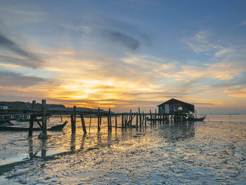 Pier over sea against sky during sunset