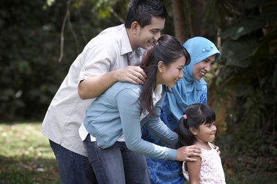 Portrait of smiling family standing on grass