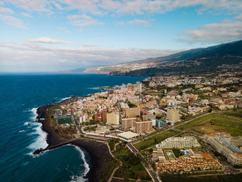 High angle view of townscape by sea against sky