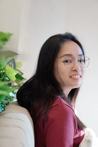 Portrait of young woman standing against white background