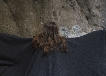 Rear view of woman standing against wall