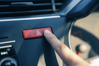 Close-up of hand holding smart phone in car