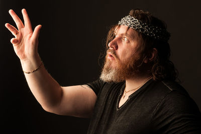 Portrait of man looking away against black background