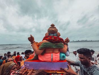 People at beach against sky