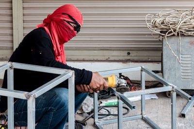 Man holding umbrella while standing on railing