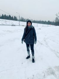 Full length of woman standing on snow covered land