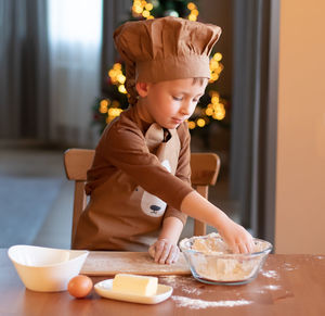 Cute boy preparing cookies at home