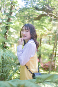 Portrait of young woman standing in forest