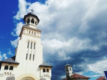 Low angle view of buildings against cloudy sky