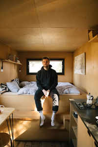 Young woman sitting on sofa at home