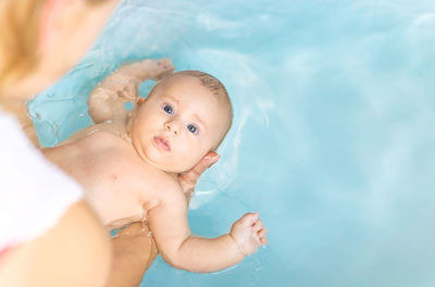 Portrait of cute baby boy lying on bed