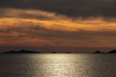 Scenic view of sea against dramatic sky during sunset