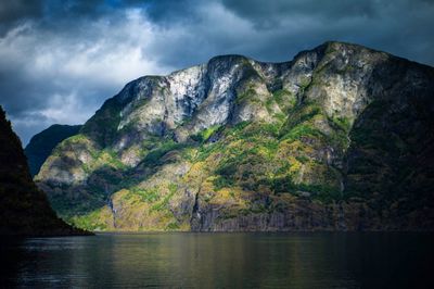 Scenic view of lake and mountains against cloudy sky